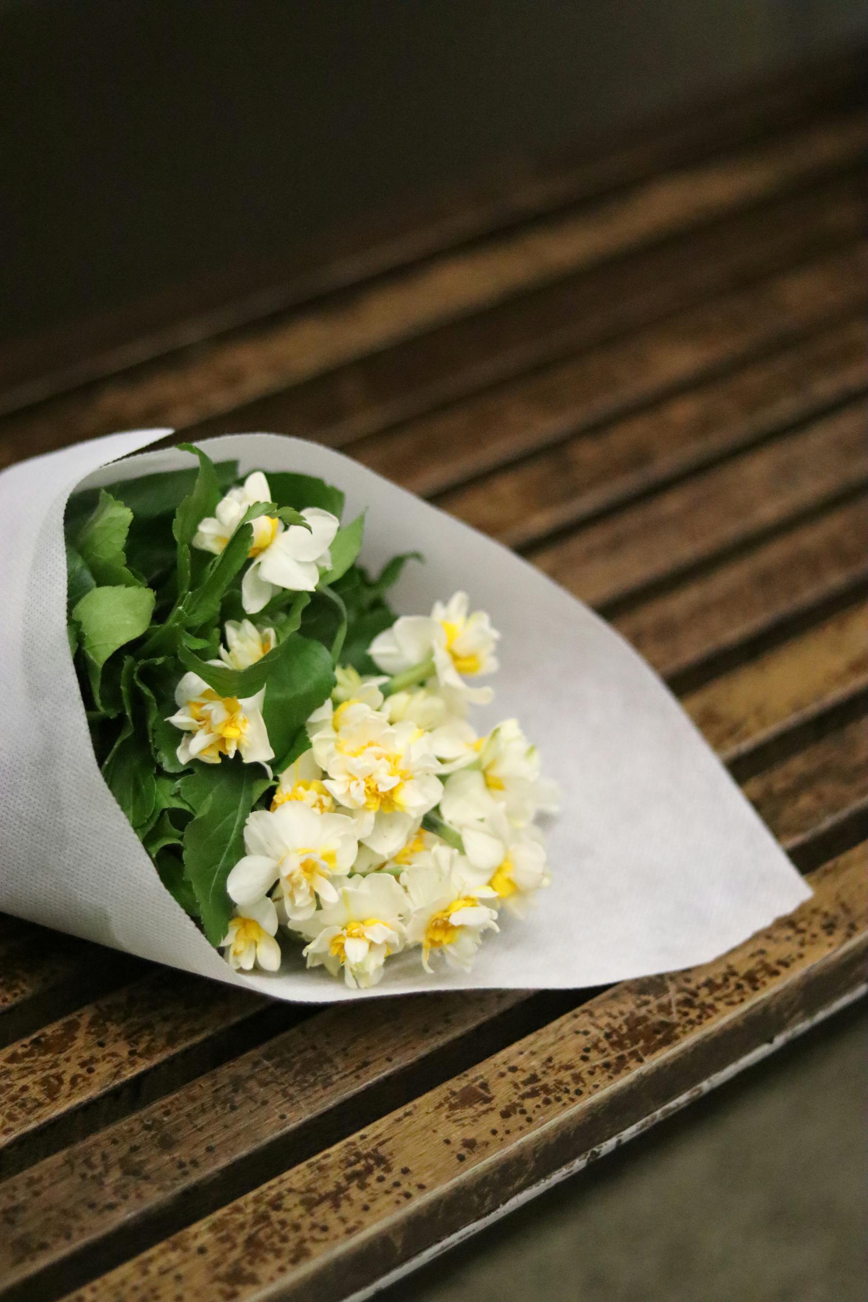 A bouquet of fresh white jasmine flowers arranged on a rustic wooden table. Perfect for natural decor.