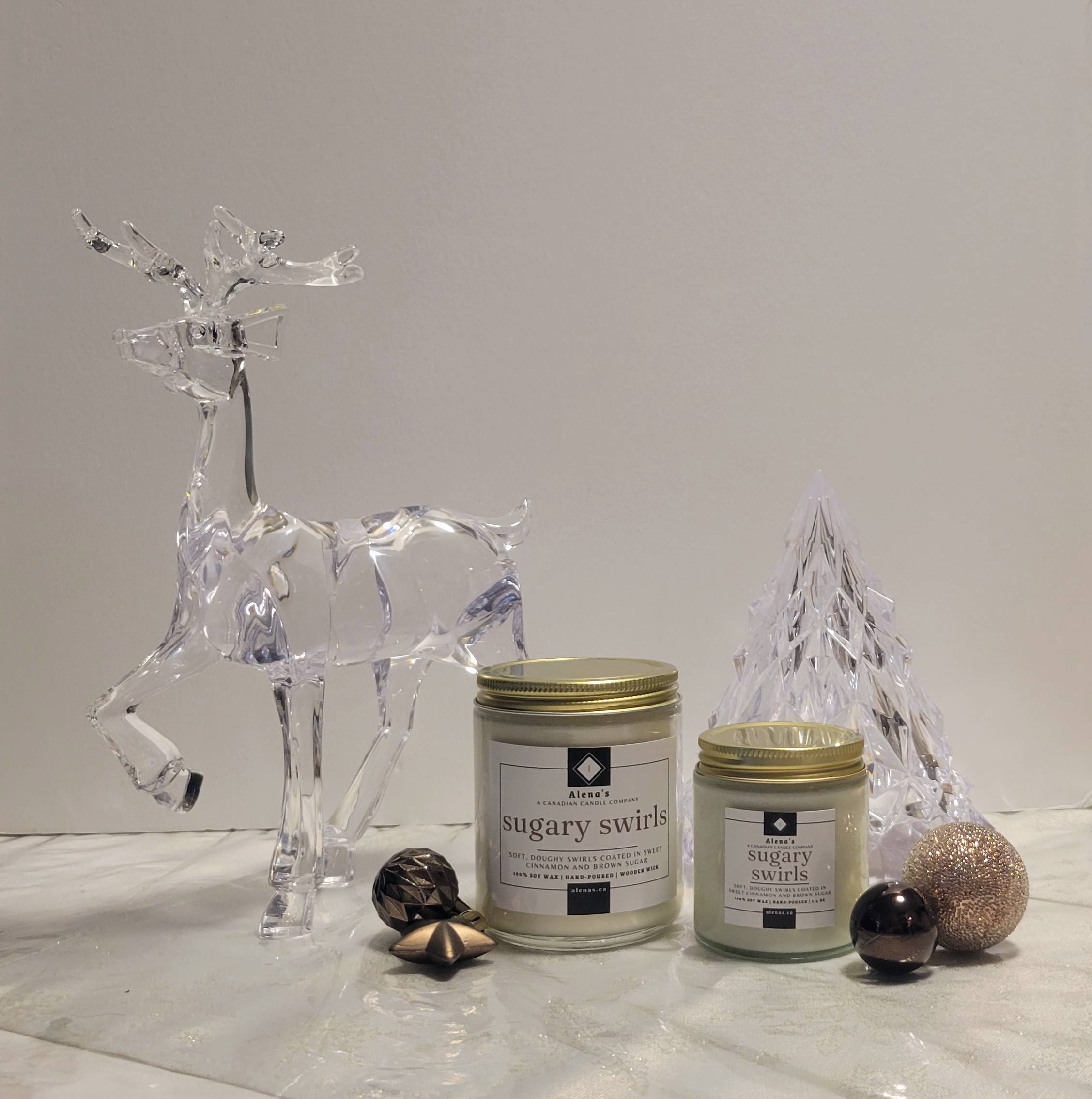 Alena’s Sugary Swirls soy wax candle in gold collection jar with crackling wooden wick, surrounded by vanilla frosting, caramel drizzle, and sparkling sugar — a cozy holiday candle hand-poured in Markham, Ontario.