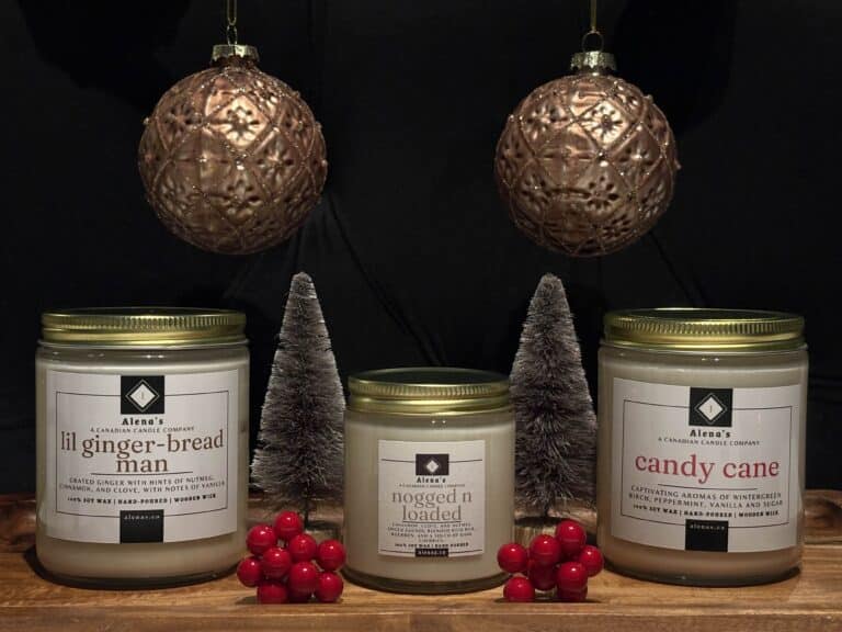 Alena’s Holiday Trio Candle Collection featuring Lil Gingerbread Man, Nogged N Loaded, and Candy Cane soy wax candles with wooden wicks in festive gold tins.
