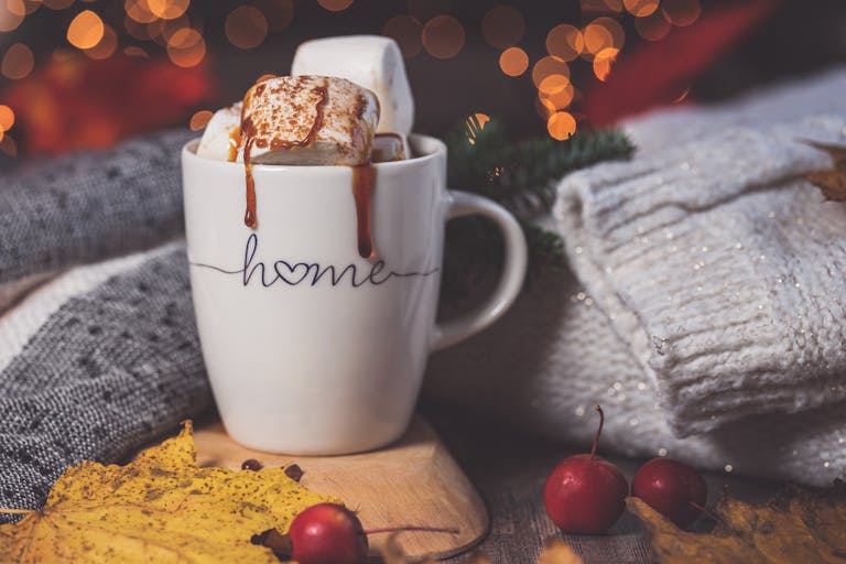 Customer Favourites — Start Here 21 Warm autumn setting with a mug of hot drink, marshmallows, and cozy knitwear.