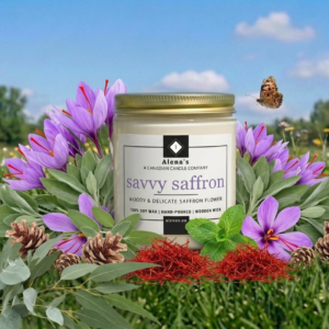 savvy saffron scented candle with a wooden wick in a gold lidded jar, surrounde by saffron flowers and spices on a green grass background with a clear blue sky